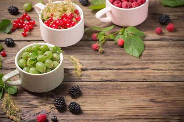 Verschiedene Beeren auf altem Holzgrund — Stockfoto