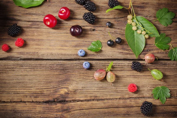 Verschiedene Beeren auf altem Holzgrund — Stockfoto