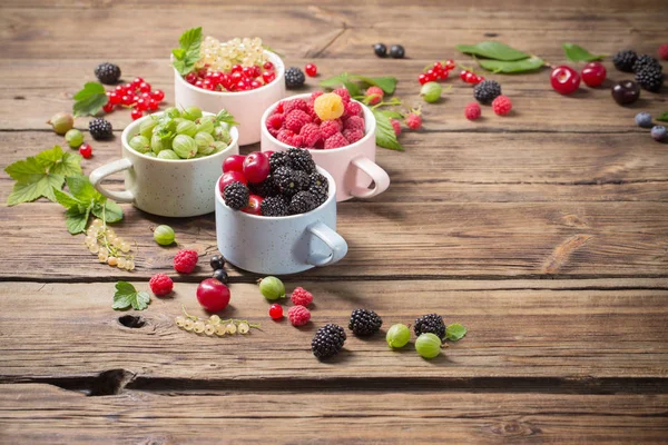 Verschiedene Beeren auf altem Holzgrund — Stockfoto