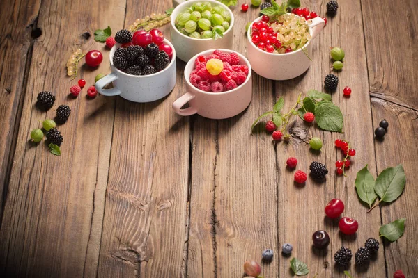 Different berries on old wooden background Stock Picture