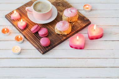 Beyaz ahşap ba kek ve yanan mumlar ile kahve fincan