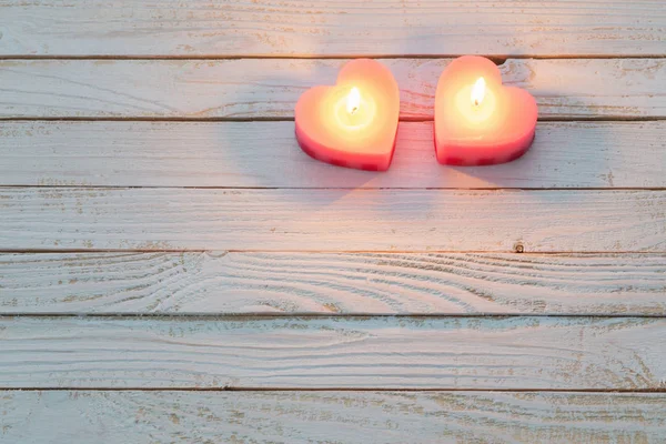 Rosa queimando velas no fundo de madeira branco — Fotografia de Stock