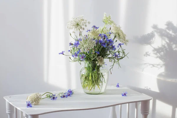 Mazzo di fiordalisi in vaso su ripiano in legno bianco — Foto Stock