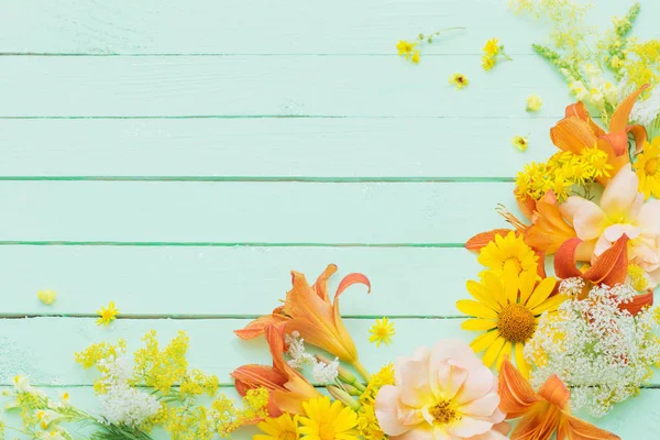 Fiori gialli e arancioni su sfondo verde in legno — Foto Stock