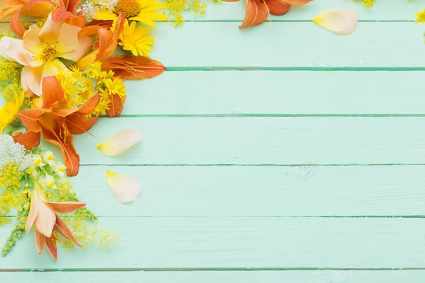 Yellow and orange flowers on green wooden background — Stock Photo, Image
