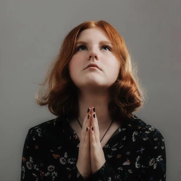 Meisje met rood haar gevouwen haar handen in gebed — Stockfoto