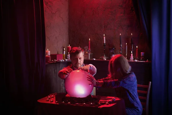 Man and woman  fortune tellers with illuminated crystal ball — Stock Photo, Image