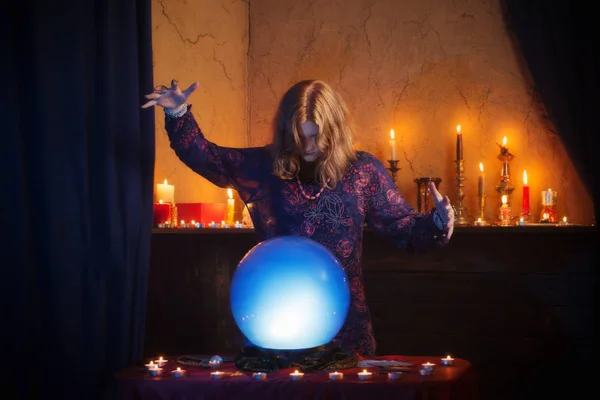 Jovem bruxa com bola de cristal iluminado — Fotografia de Stock