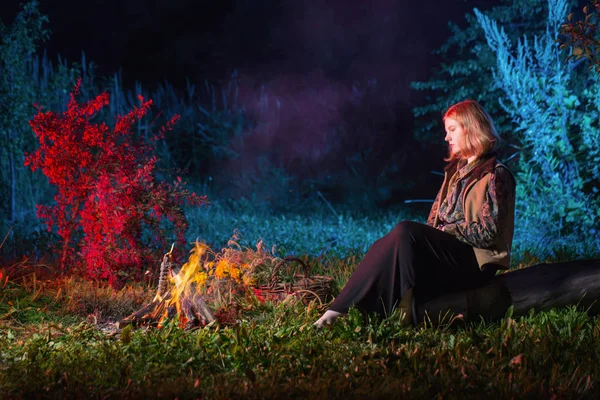 Jeune sorcière par le feu de nuit dans la forêt — Photo