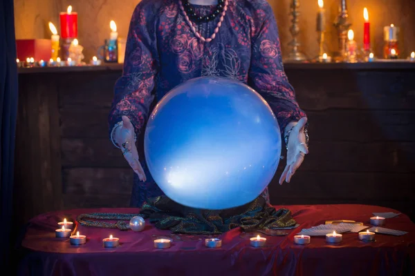Hands of fortune teller with illuminated crystal ball — Stock Photo, Image