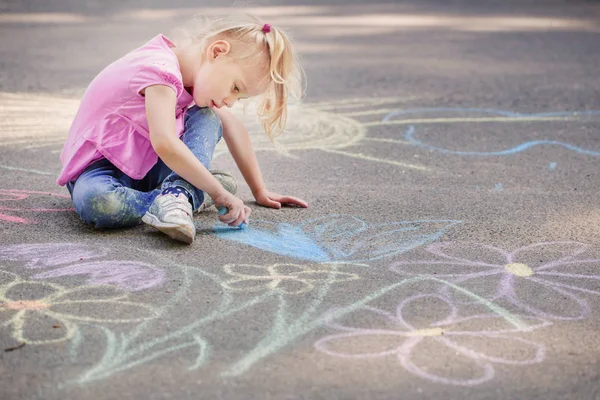 少女は歩道にチョークで絵を描き — ストック写真