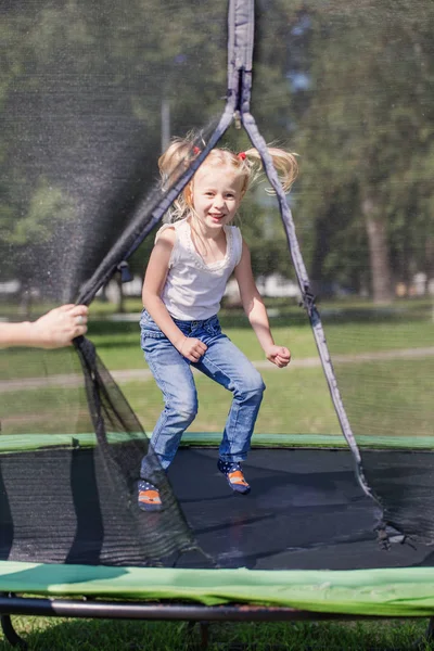 Mädchen springt im Park auf Trampolin — Stockfoto