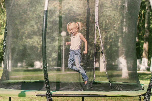 Девушка прыгает на батуте в парке — стоковое фото