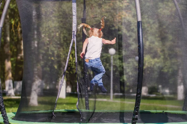 Girl jumping on  trampoline in park — Stock Photo, Image