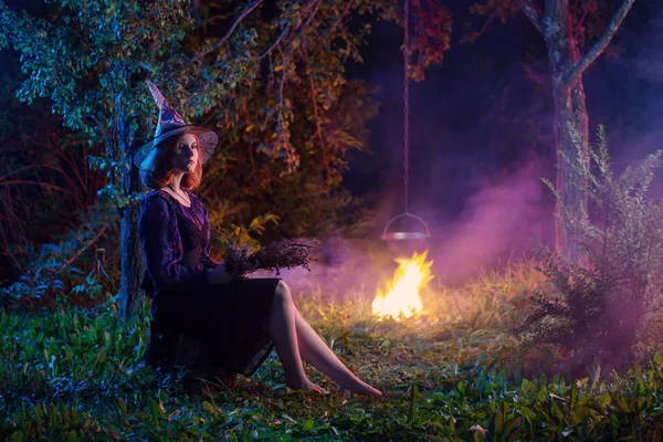 Young witch by  fire in night forest — Stock Photo, Image