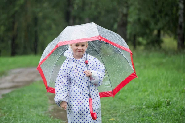 Divertente bambina con ombrello sotto la pioggia — Foto Stock