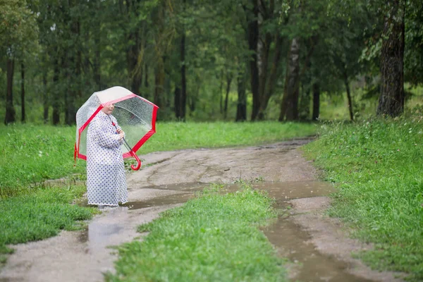 Αστείο μικρό κορίτσι με ομπρέλα στη βροχή — Φωτογραφία Αρχείου