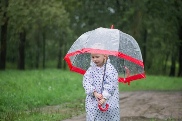 Funny little girl with umbrella in rain — Stock Photo, Image