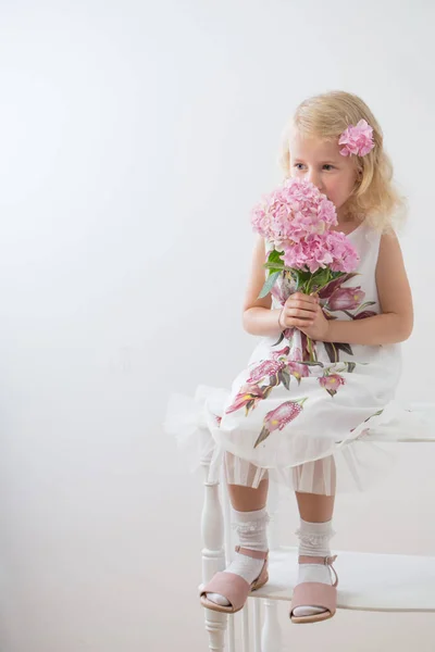 흰색 백그로에 분홍색 꽃과 아름다운 작은 금발의 소녀 — 스톡 사진