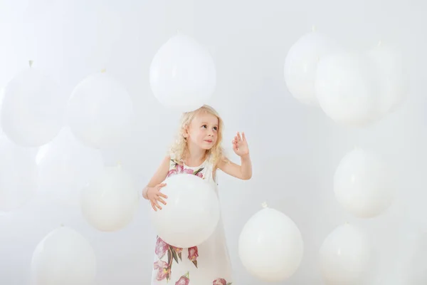 Klein meisje met witte ballonnen indoor — Stockfoto