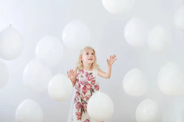 Little girl with white balloons indoor — Stock Photo, Image