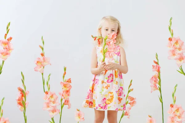 Szép kis szőke lány virágok fehér háttér — Stock Fotó