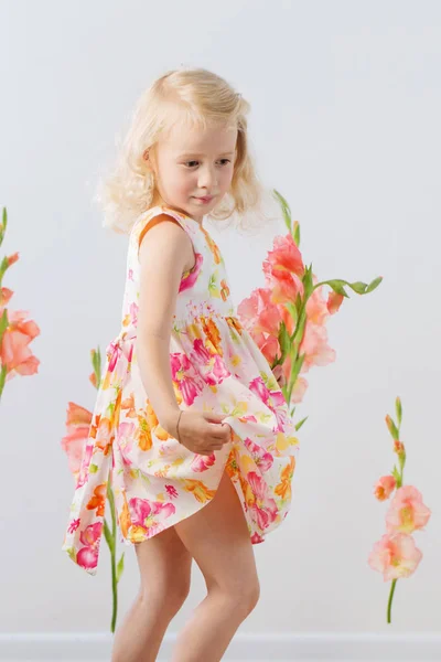 Beautiful little blonde girls with  flowers on white background — Stock Photo, Image