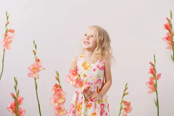 Hermosas niñas rubias con flores sobre fondo blanco —  Fotos de Stock