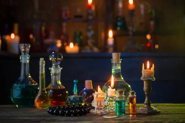 Magiczne mikstury w butelkach na drewnianym stole — Zdjęcie stockowe