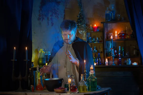 Portrait de sorcier avec des bougies allumées et des potions magiques — Photo
