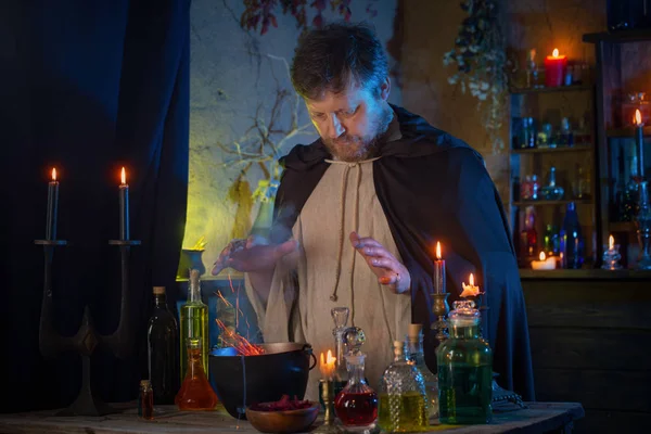 Portrait of  wizard with burning candles and magic potions — Stock Photo, Image
