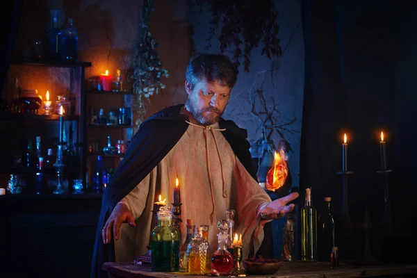 Portret czarodzieja z płonącymi świecami i magicznymi eliksirami — Zdjęcie stockowe