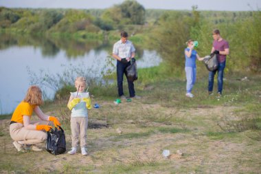 aile yaz aylarında sahilde çöp toplar