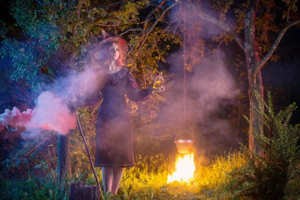 Jeune sorcière par le feu dans la forêt nocturne — Photo