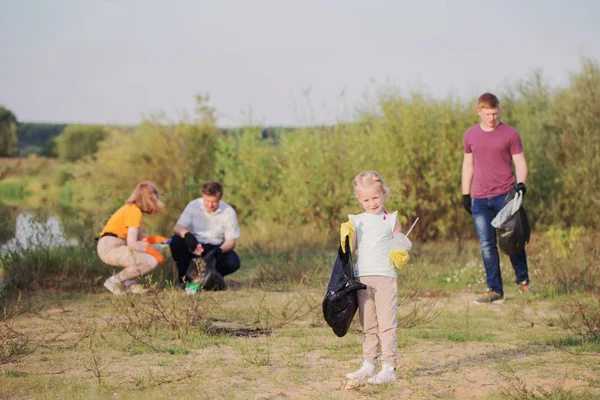 Family picks up trash on the beach in summer — Stock Photo, Image