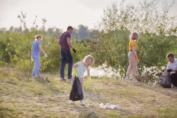 Família pega lixo na praia no verão — Fotografia de Stock