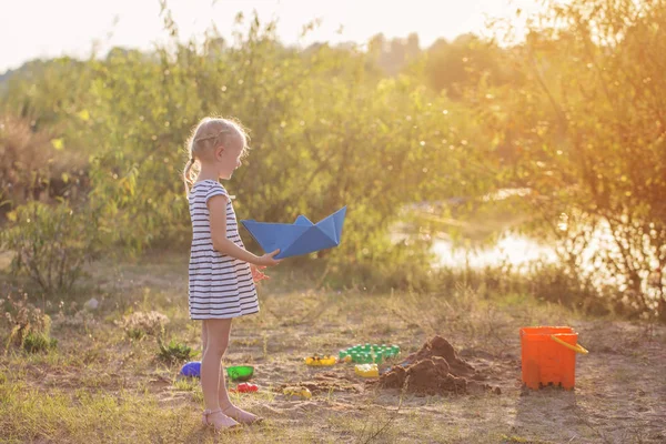 Маленькая девочка играет на песке с игрушками — стоковое фото