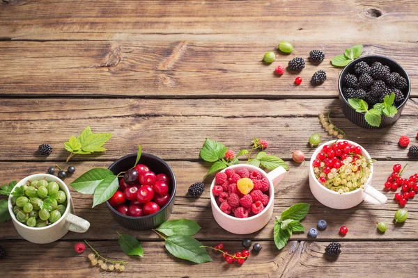 Verschiedene Beeren auf altem Holzgrund — Stockfoto