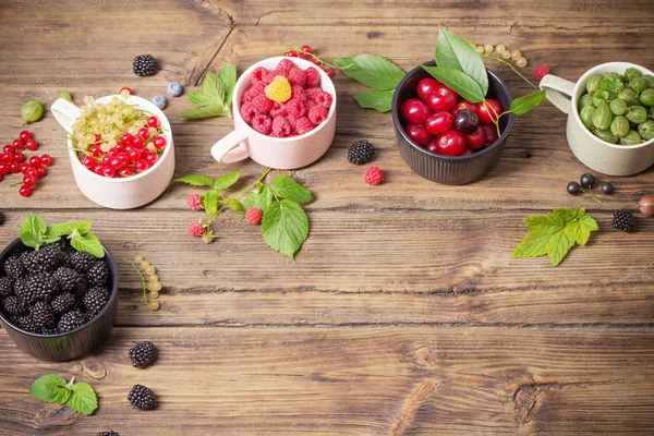 Verschiedene Beeren auf altem Holzgrund — Stockfoto