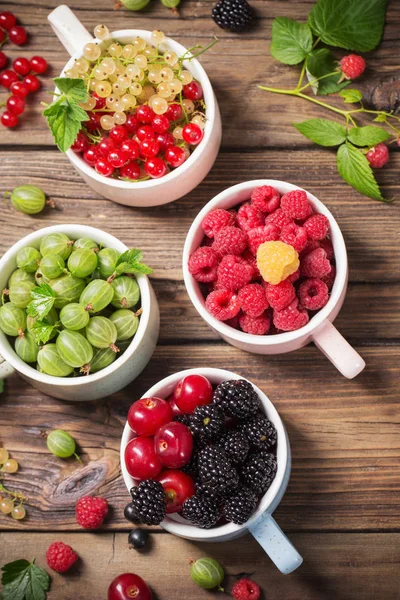 Verschiedene Beeren auf altem Holzgrund — Stockfoto