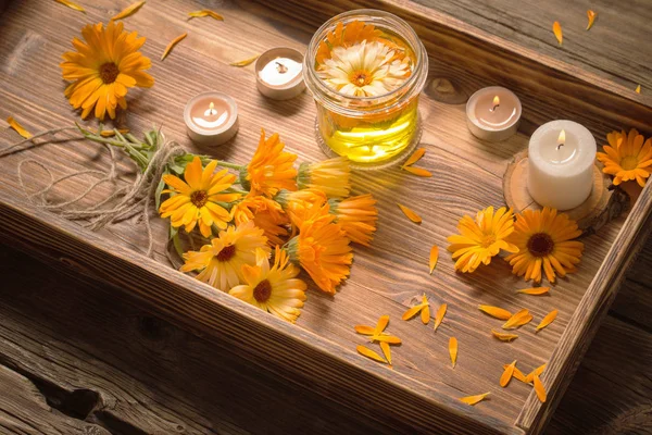 Medicinal flowers of calendula with burning candles  on dark woo