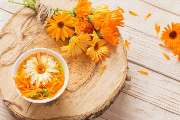 Flores medicinais de calêndula no fundo de madeira branco — Fotografia de Stock