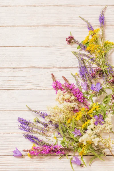 Vildblommor på vit trä bakgrund — Stockfoto