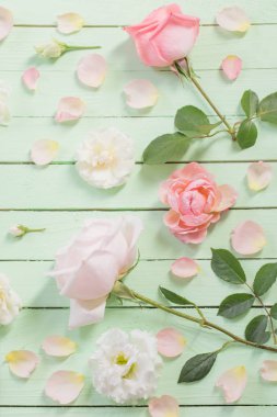 yeşil ahşap arka plan üzerinde pembe ve beyaz güller 