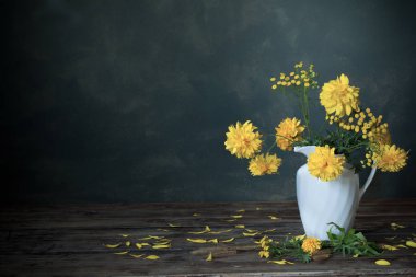 koyu arka plan üzerinde beyaz sürahi yeliow çiçekler