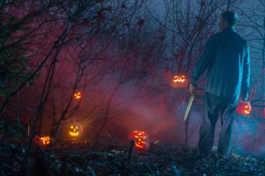 gece ormanında korkunç adam Halloween kabak kesiyor
