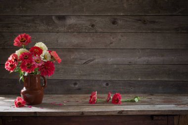 eski ahşap zemin üzerine Vazoda Çiçekler