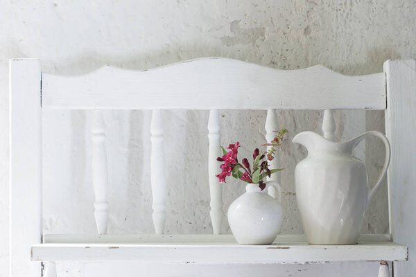 flowers in white vase on old wooden shelf