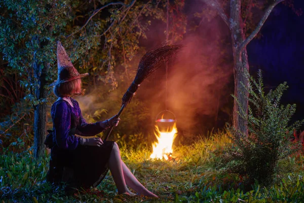 Young witch by  fire in night forest — Stock Photo, Image