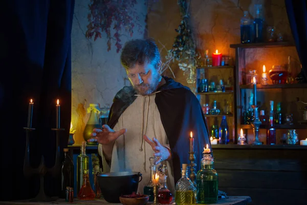 Portrait of  wizard with burning candles and magic potions — Stock Photo, Image